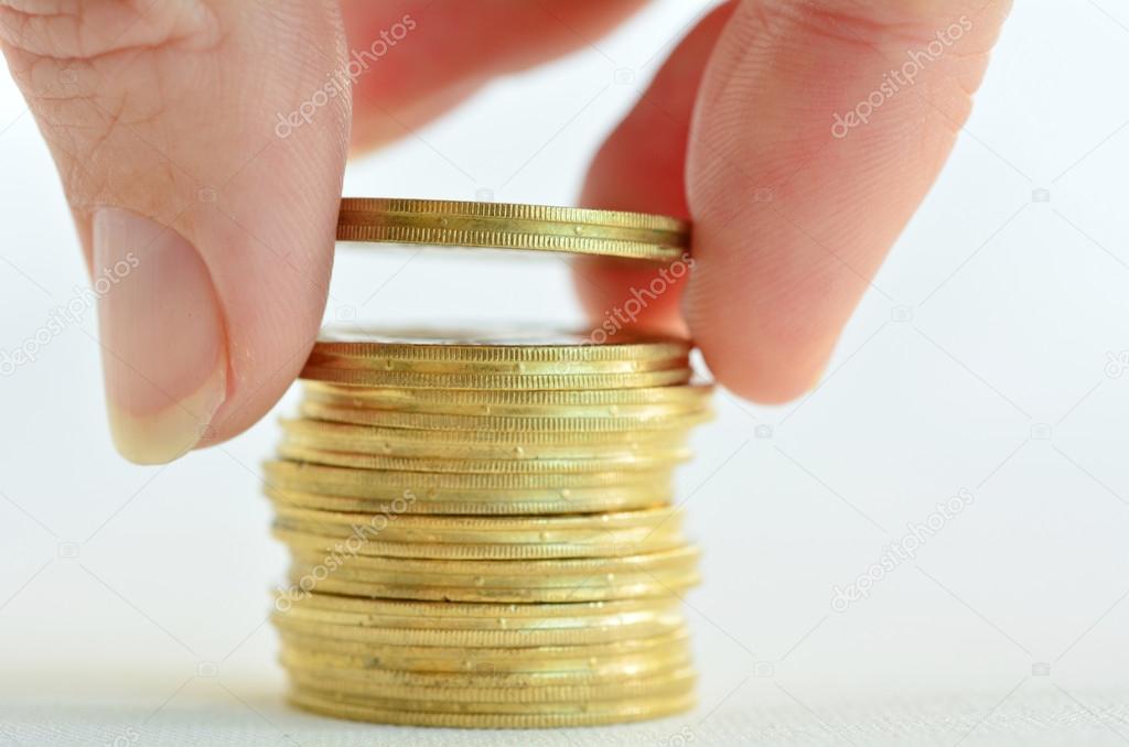 Female hand stacking gold coins