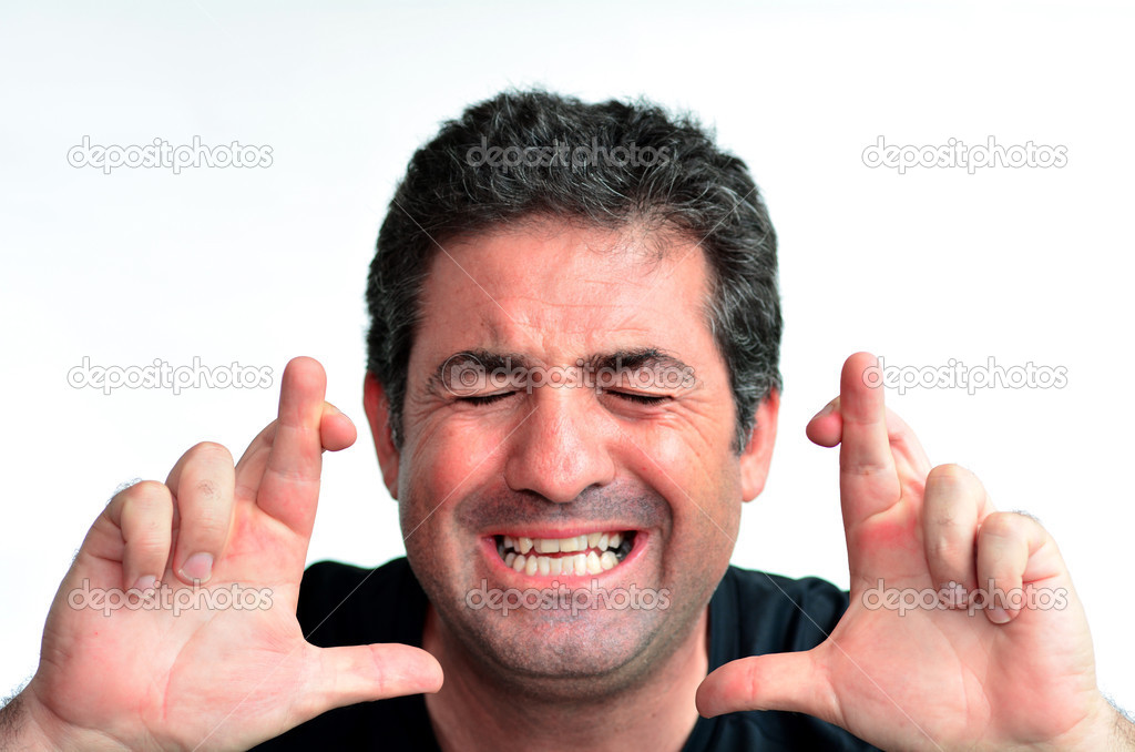Mature man with crossed fingers hoping for luck