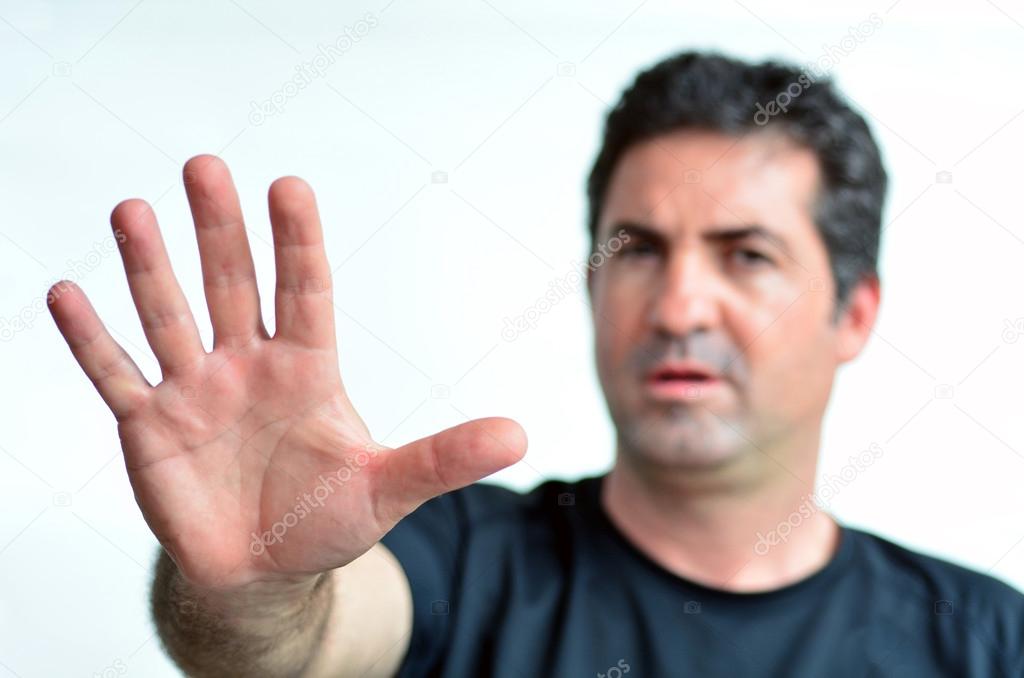 Upset mature man show stop sign with his palm. 