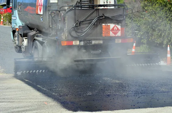 Veículo de caminhão de alcatrão alcatrão uma peça de estrada nova — Fotografia de Stock