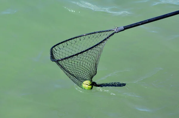 Pelota de tenis en la red de mano — Foto de Stock