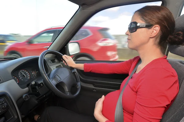 Těhotná žena řídit auto — Stock fotografie