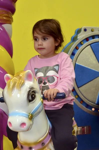 Little girl ride on carousel horse — Stock Photo, Image