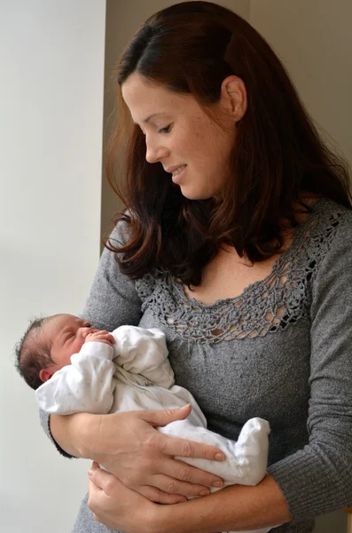 Moeder houdt haar pasgeboren baby — Stockfoto