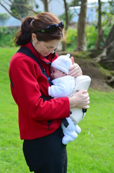 Anne bebek taşıyıcı üzerinde yeni doğan bebek taşımak — Stok fotoğraf