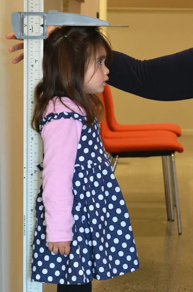 Enfermeira pediatra examinando a altura da criança — Fotografia de Stock