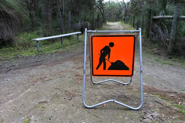 Road work sign men at work on a public park path.