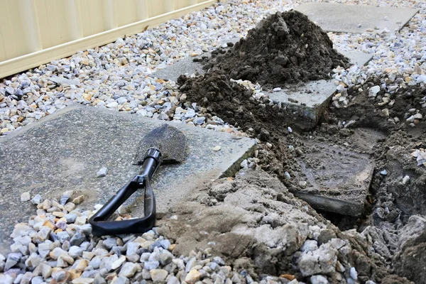 地下热水管道漏水的小铲子埋在地上的一个孔边 — 图库照片