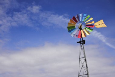 Avustralya 'nın taşrasındaki mavi gökyüzünde izole edilmiş renkli rüzgar değirmeni.