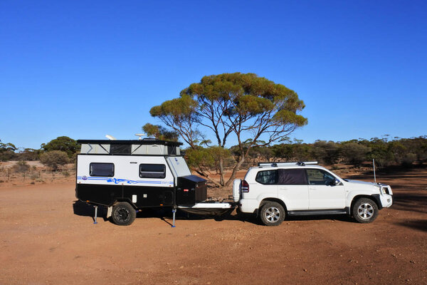 KOOKYNIE, WA - MAR 25 2022:Towing vehicle and a caravan camping in the outback.Registration of caravans has increased throughout Australia as a way to see more of the wonderful Australian outdoors.