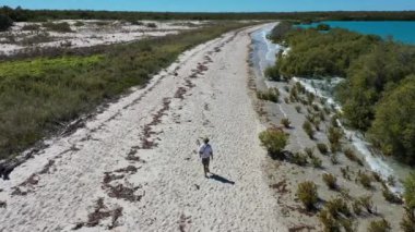Aerial landscape view of Australian man walking on empty wild beach in Cape Leeuwin in the Kimberley region, Western Australia