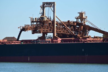 PORT HEDLAND, WA - JUNE 24 2022:Loading Berthed Iron Ore Ship, Port Hedland, Western Australia.The port exported 519,408,000 tonnes (1.1 trillion pounds) of iron ore (20172018). clipart