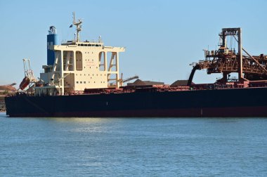 PORT HEDLAND, WA - JUNE 24 2022:Loading Berthed Iron Ore Ship, Port Hedland, Western Australia.The port exported 519,408,000 tonnes (1.1 trillion pounds) of iron ore (20172018).