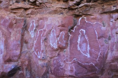 WYNDHAM, WA - AUG 12 2022:Australian Aboriginal mythology of human figures rock paintings on a rock cave in Kimberley Western Australia.