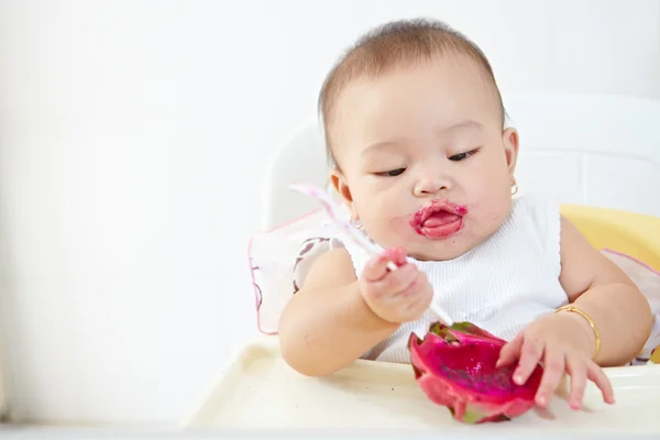 Bebê comendo fruta dragão — Fotografia de Stock