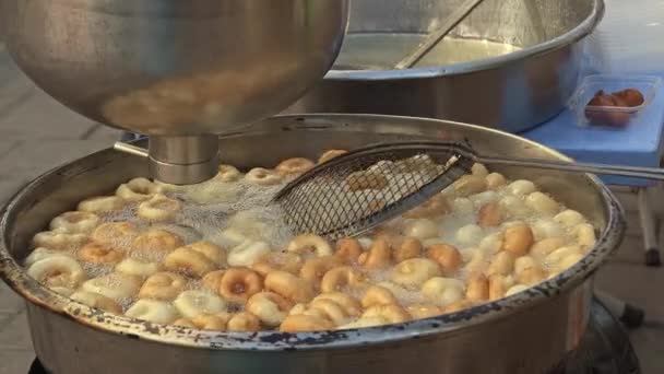 トルコの伝統的な甘いルックマ ボール またはバゲル酵母の生地は 沸騰油で揚げられます 甘い砂糖シロップの屋台で販売されています 場合によっては 葬儀の数日後にゲストに無料で配布されます — ストック動画