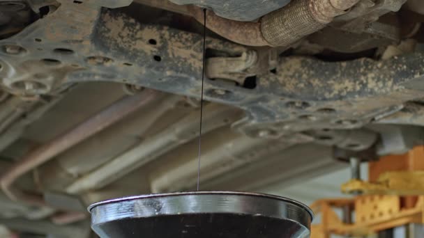 修理工場で車のエンジンの古いオイルを排水 — ストック動画