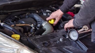 Araba Tamircisi Motor yağı seviyesini kontrol ediyor..