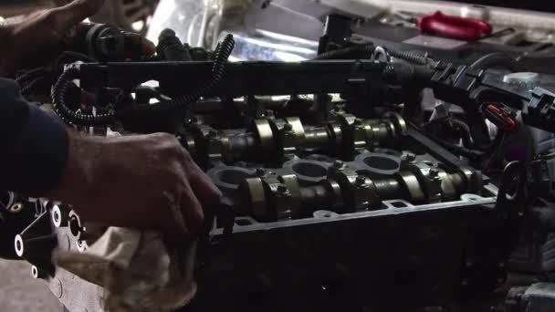 修理店的汽车技工用布片清洗重新组装的发动机的零件 — 图库视频影像