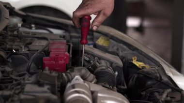 Car Master Repairs Car Engine With Screwdriver In Repair Shop