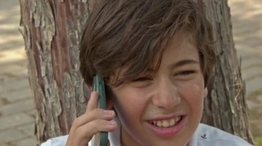 Cep telefonuyla konuşan genç çocuk..