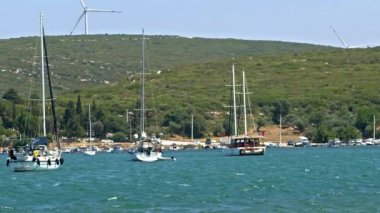 Denizde Eğlence Tekneleri ve Dağlarda Elektrik Rüzgarı Türbini.