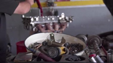 Tamir atölyesinde elden geçirilmiş araba motoru parçaları monte ediliyor..