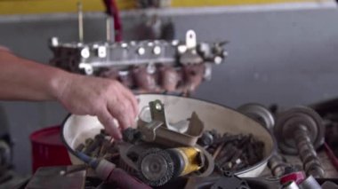 Tamir atölyesinde elden geçirilmiş araba motoru parçaları monte ediliyor..