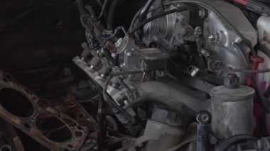 Arızalı Araç Motoru ve Tamirhanedeki Parçalar.