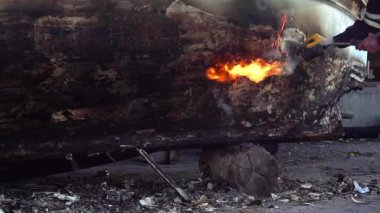 Ahşap bir balıkçı teknesinde Yanan ve Ateşle Boyayı Kaldıran.