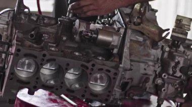 Car Master Assembles Refurbished Car Engine Parts With Air Screwdriver In Workshop Footage.