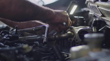 Removing the Car Turbo Pump in the Repair Shop with a Double Wrench.