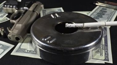 Smoky Table Video 'da Silah Kurşunu ve Dolar Banknotları.