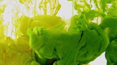 Soyut Yeşil ve Sarı Mürekkep Damlaları Suda Yayılıyor.