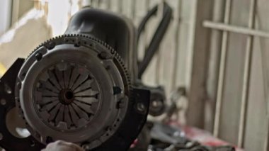 Tamir atölyesindeki araba motorunda debriyaj pedi değiştirme.