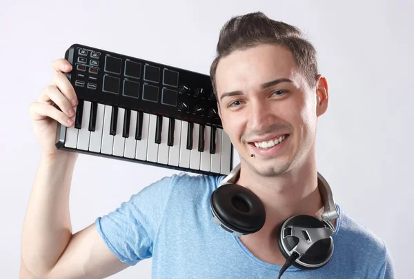 Deejay with headphones and midi keyboard on shoulder — Stock Photo, Image