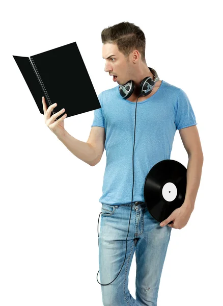 Sorprendido joven deejay sosteniendo vinilo y aprendiendo de libro negro — Foto de Stock