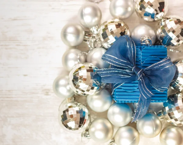 Bovenaanzicht van blauwe doosje omringd door zilveren kerstballen — Stockfoto