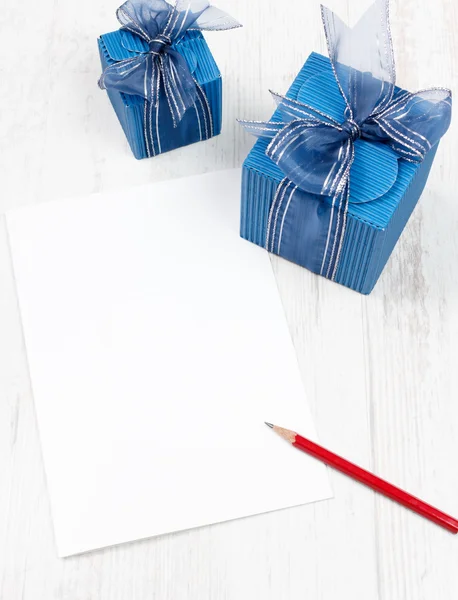 Carton with red pencil in front of blue gift boxes — Stock Photo, Image