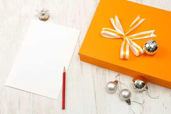 Caja de regalo naranja cerrada con adornos de Navidad de plata — Foto de Stock