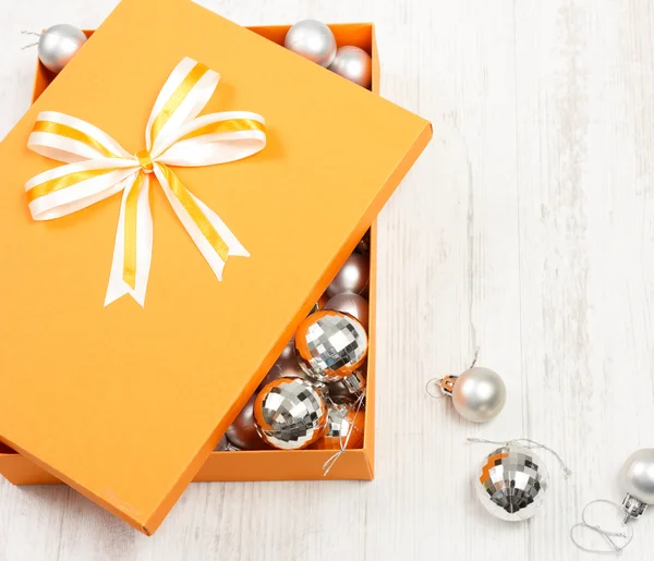 Boîte cadeau de Noël orange remplie de boules d'argent — Photo