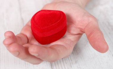 avuç içinde kırmızı kadife mücevher kutusu yerleştirilmiş