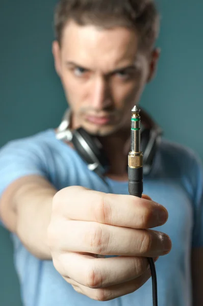 Young guy holding stereo jack plug — Stock Photo, Image