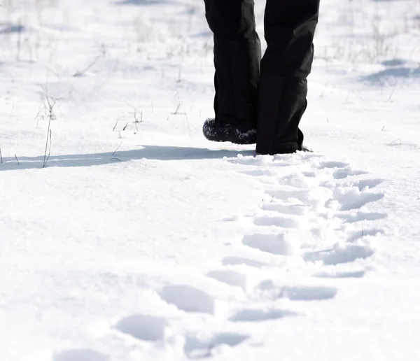 Persona caminando en la nieve y dejando huellas —  Fotos de Stock