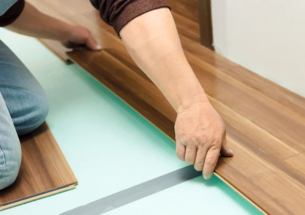 Homem que coloca parquet no quarto limpo — Fotografia de Stock