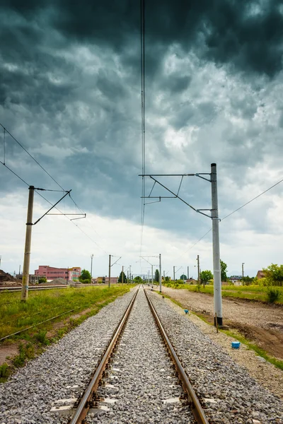 Straight railroad with dark cloudy sky — Stock Photo, Image