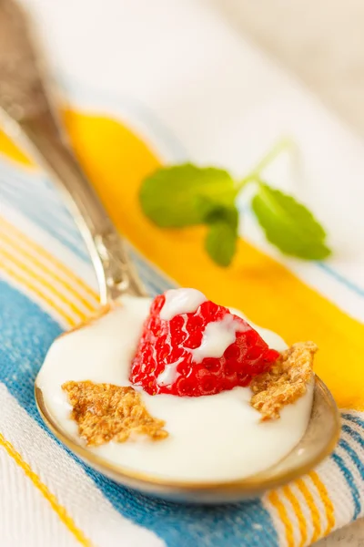 Çilek parçaları ile tahıl ve içinde kaşık yoğurt — Stok fotoğraf