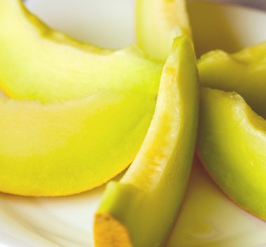 Sarı kavun beyaz tabağa dilimlenmiş