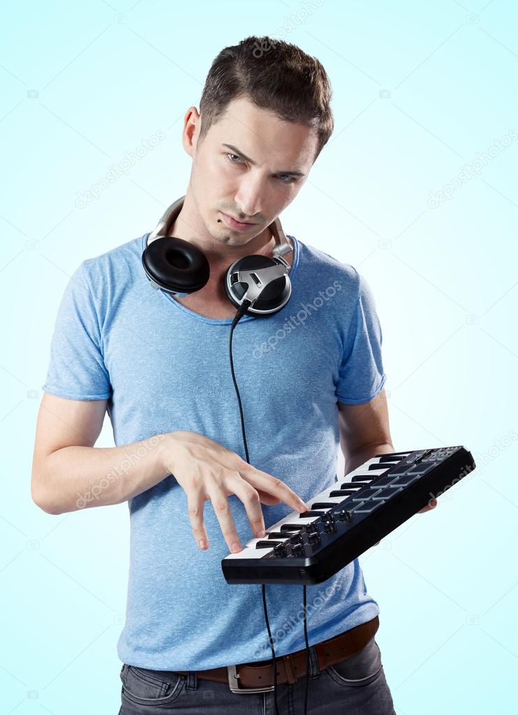 Deejay with headphones pressing keys on midi keyboard