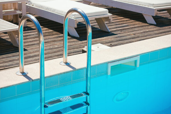 Chrome stairs with empty swimming pool